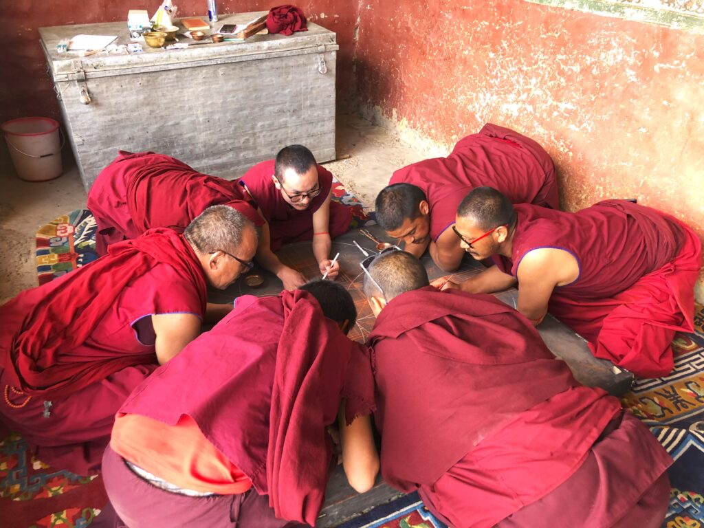 Buddhistische Mönche in Ladakh bei der Vorarbeit zu einem Sandmandala